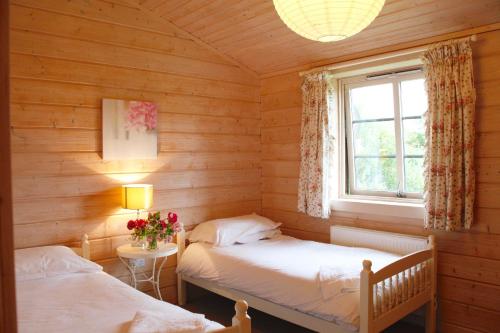 two beds in a room with a window at Skylark Lodge in Dumfries