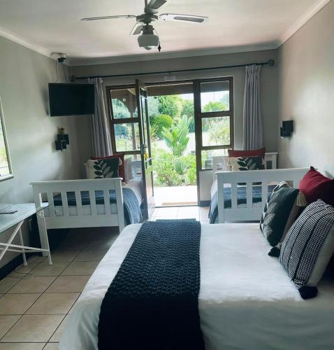 a bedroom with two white beds and a window at African Sun Guest House in Molen Drift