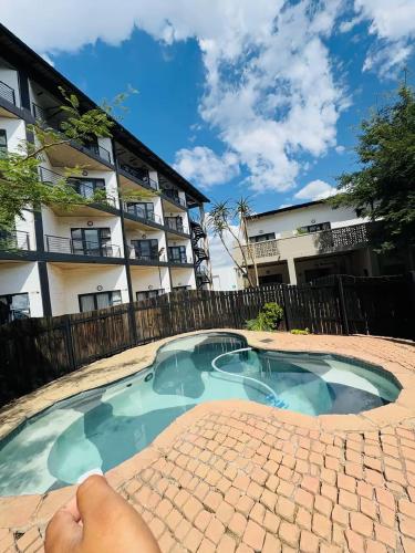 a swimming pool in front of a building at 201 On Main in Johannesburg