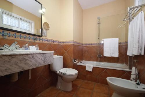 a bathroom with a toilet and a sink and a tub at Hotel Sierra de Cazorla & SPA 3* in Cazorla