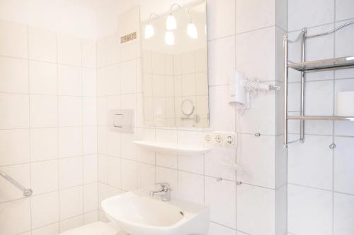 a white bathroom with a sink and a toilet at Forest Monteurzimmer & Fewo für Firmen & Gruppen in Bad Bevensen