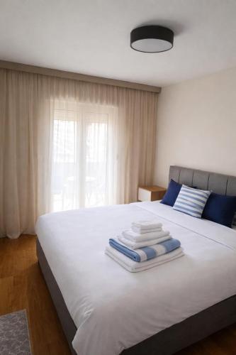a bedroom with a white bed with towels on it at Premium Rent Podgorica in Podgorica