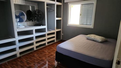 a small bedroom with a bed and a window at Refúgio Beira-Mar in Itanhaém