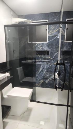 a bathroom with a glass shower with a toilet at Refúgio Beira-Mar in Itanhaém