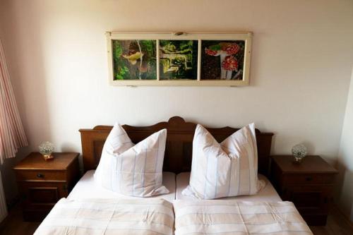 a bedroom with a bed with white sheets and pillows at Pension zum Lusenblick in Mauth