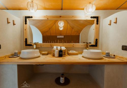 a bathroom with two sinks and a large mirror at Dihya Luxury Camp in Merzouga