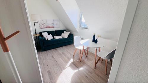a living room with a green couch and a table at Cabourg-Angle bleu in Cabourg