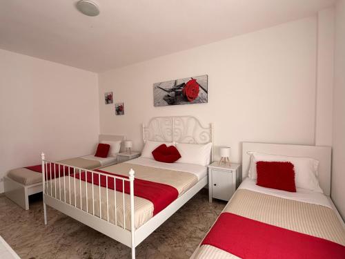 a bedroom with two beds with red pillows at Casa Sant'Antonio in Bari