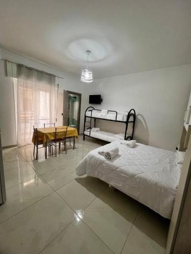a bedroom with a bed and a dining room with a table at Affittacamere La bottega del barbiere in Scalea