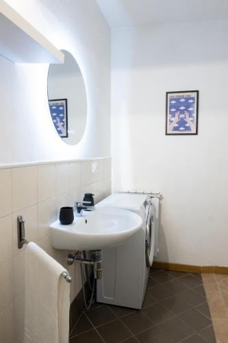a white bathroom with a sink and a mirror at Titina Apartment Novoli Close to Center & Airport in Florence