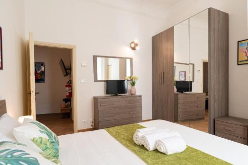 a bedroom with two towels on a bed with a mirror at Titina Apartment Novoli Close to Center & Airport in Florence
