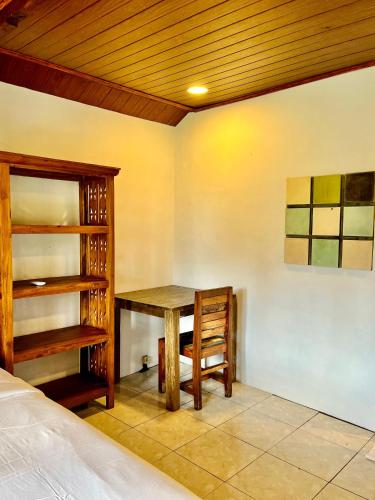 a room with a table and a chair and a bed at Sawit House by Natural View in Karangasem