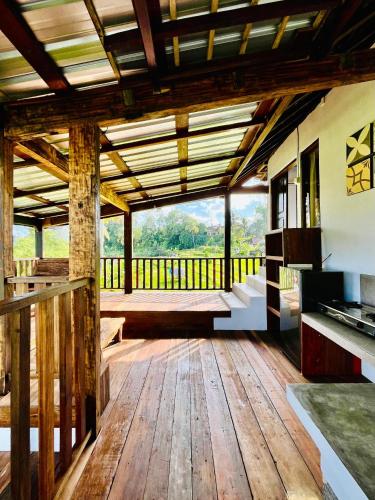 a large room with wooden flooring and a large window at Sawit House by Natural View in Karangasem