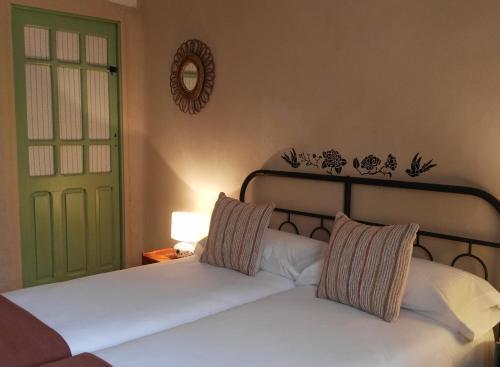 a bedroom with a bed and a green door at El Rincon 53 in Quintanilla del Monte
