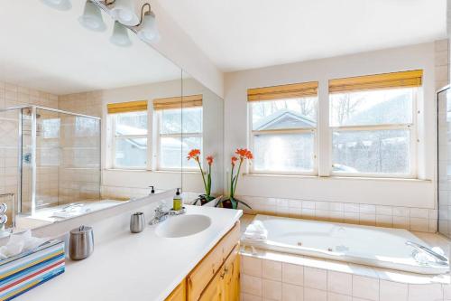 a white bathroom with a tub and a sink at Sun Bird Getaway at River Run in Ketchum