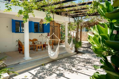 a house with two hammocks on a patio at Casa Omero. in El Cuyo