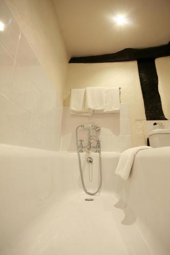 a bath tub with a shower in a bathroom at Crown Hotel in Nantwich