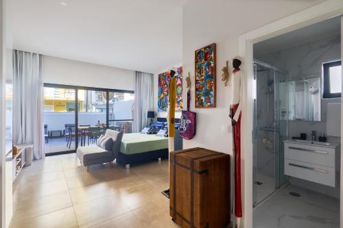 a living room with a bed and a room with a kitchen at Edificio Lux's - Apartamentos Tubarão in Santa Maria