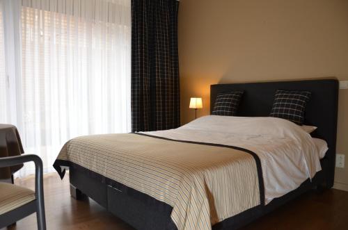 a bedroom with a large bed with a window at B&B La Romance du Lac in Robertville