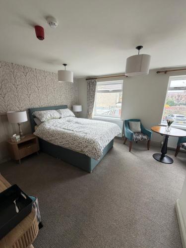 a bedroom with a bed and a table and chairs at The Blue Bell Inn in Amble