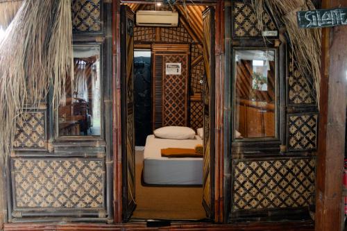 a small bedroom with a bed in a room at Da Housetel Kuta in Kuta
