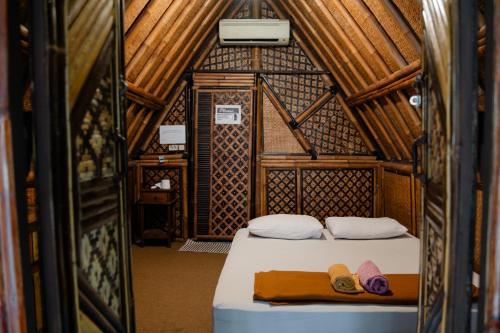 a bed in a room with two slippers on it at Da Housetel Kuta in Kuta