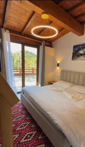 a bedroom with a bed with a ceiling fan at Guesthouse Alberti Llogara in Shalë