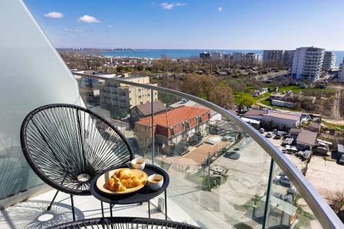 a plate of food on a table on a balcony at Chocolat in Odyssey Pool & Spa Resort in Mamaia Sat/Năvodari