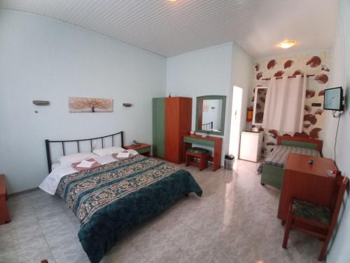 a bedroom with a bed and a table and a mirror at Panorama Rooms in Kyllini