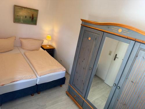 a bedroom with a bed and a dresser with a mirror at Wellenkieker in Wyk auf Föhr