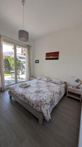 a bedroom with a bed and a large window at Appartamento La Camelia in Sondrio