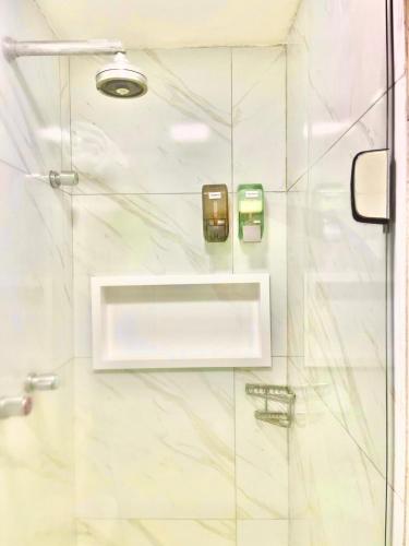 a bathroom with a shower with a glass door at HOTEL NAVEGANTES VISTA PARA MAR Boa Viagem in Recife
