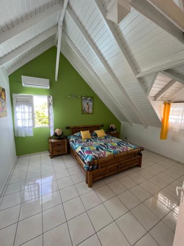 a bedroom with a bed and a green wall at Villa Caillou in Lamentin