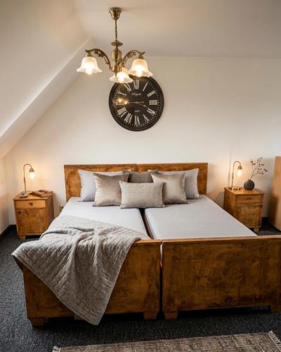 a bedroom with a large bed with a clock on the wall at Mazurska Chata Rydzewo in Rydzewo