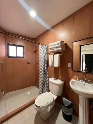 a bathroom with a toilet and a shower and a sink at Club Campestre El Eden in Yautepec de Zaragoza