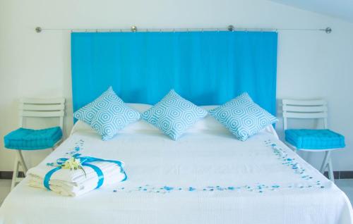a bed with a blue and white bedspread and pillows at Spacebility Airport in Cagliari