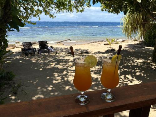two drinks on a wooden table on the beach at Tahiti Sunrise Beach in Vaitoare