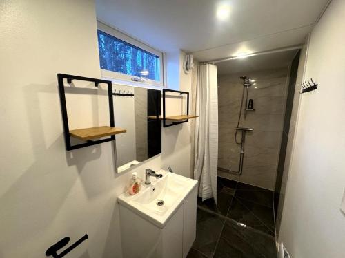 a white bathroom with a sink and a shower at Sollidsvägen 1 F in Bro