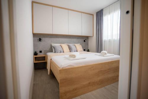 a bedroom with a large bed with white cabinets at AC Ivona - Mobile home AURORA Vodice in Vodice