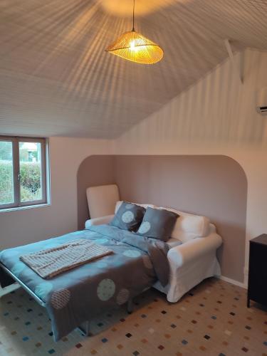 a bedroom with a bed and a couch in it at Le 13 au vert in Montigny-les-Monts