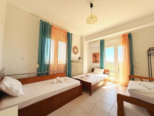 a hotel room with two beds and a window at Elena's 3BR Maisonette with Garden & Pool in Nea Plagia