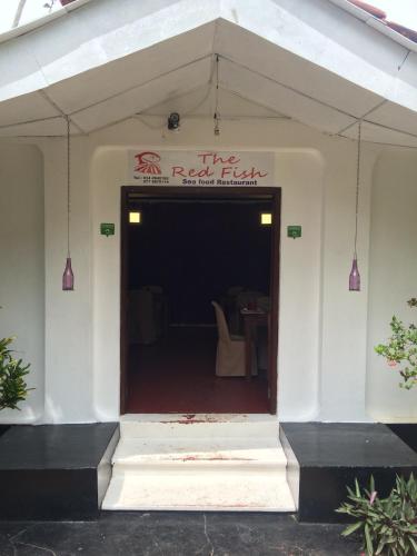 a white building with a sign that reads the red brick at Palm Beach Inn & Sea Shells Cabanas in Bentota