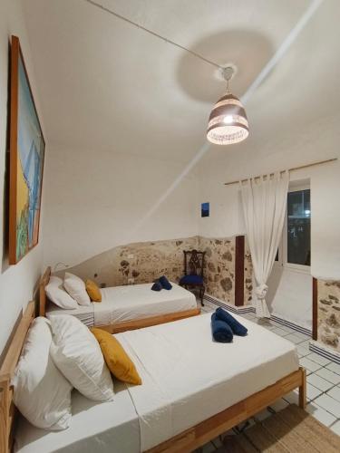 two beds sitting in a room with a lamp at Ocean front surf House El Cotillo in El Cotillo