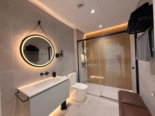 a bathroom with a sink and a toilet and a mirror at ALGAIDAMAR BEACH LUXURy in Sitio de Calahonda