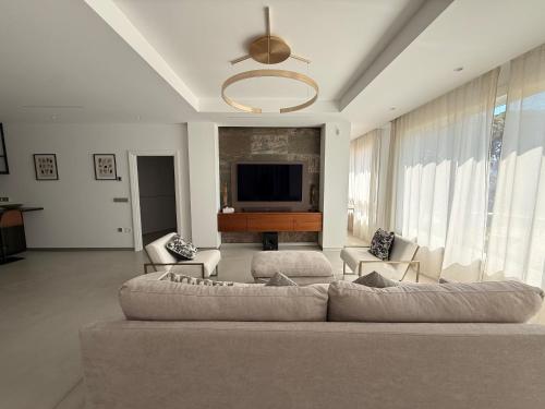 a living room with a couch and a flat screen tv at ALGAIDAMAR BEACH LUXURy in Sitio de Calahonda