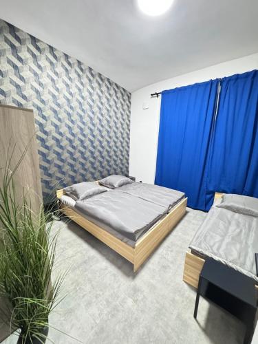 a bedroom with two beds and a blue curtain at Teplice Apartments 1 in Teplice