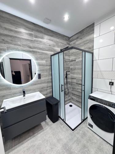 a bathroom with a shower and a sink and a mirror at Teplice Apartments 1 in Teplice