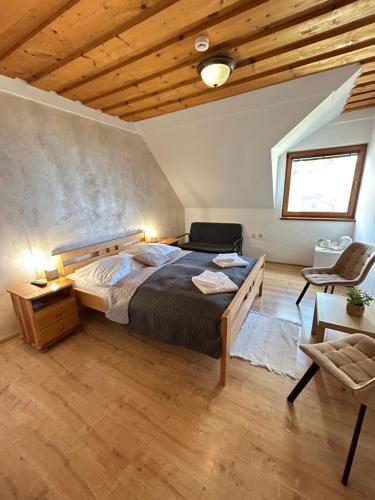 a bedroom with a large bed and a chair at Slanický Dvor in Námestovo