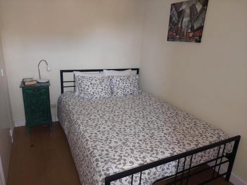 a bedroom with a bed with a black and white comforter at Beach House Largo da Agrela in Viana do Castelo