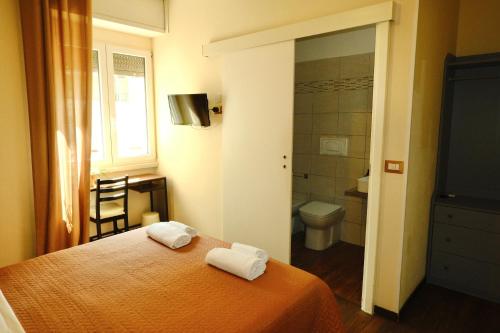a bedroom with a bed and a toilet and a window at Bergamoincity in Bergamo